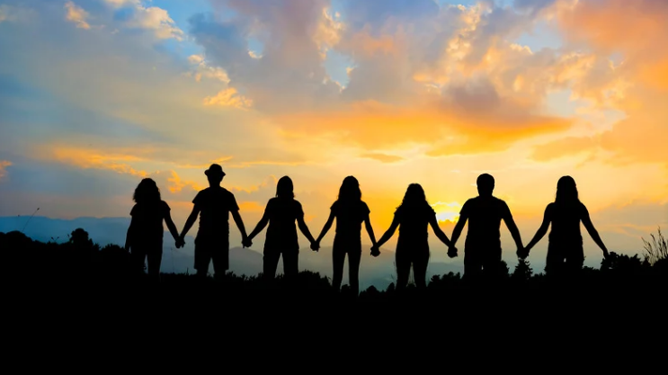 People holding hands at sunset